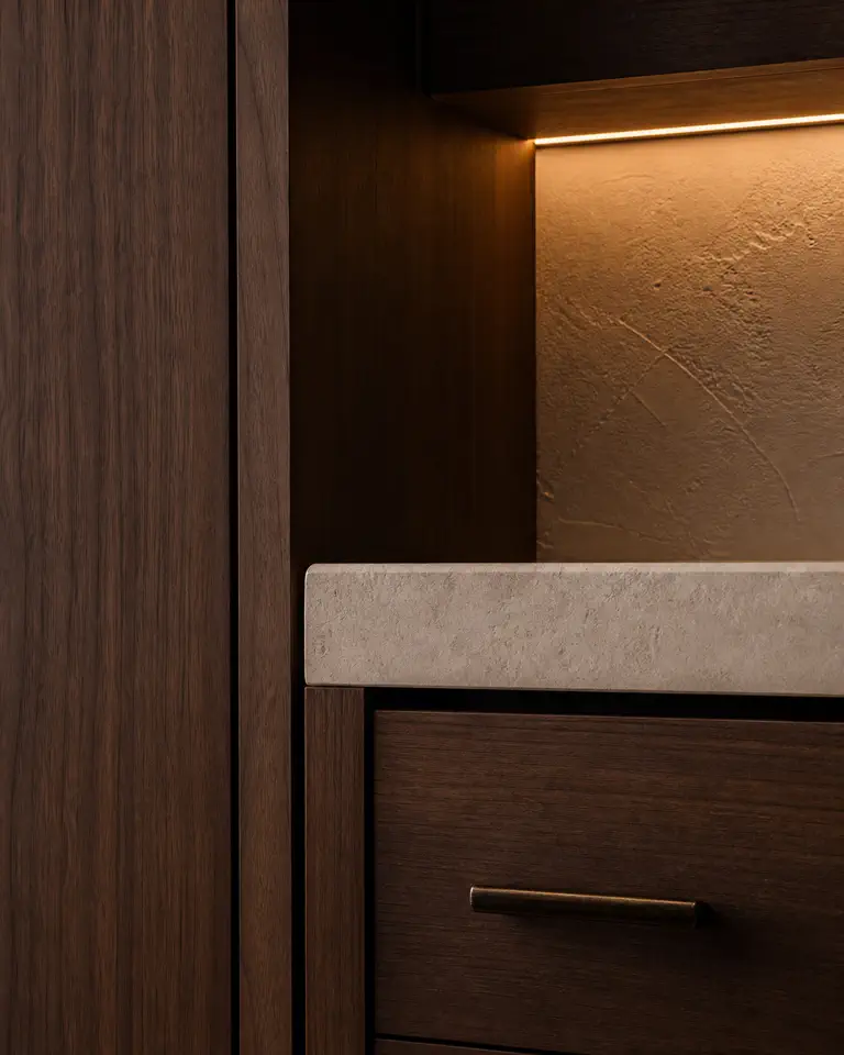 Walnut cabinetry, limestone, bronze hardware, and warm integrated light